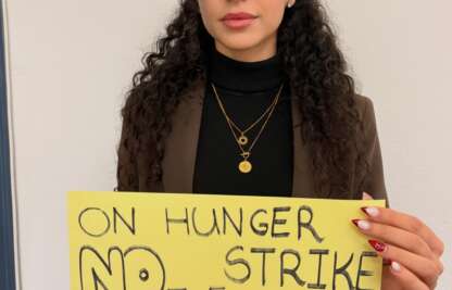 Solidaritätsaktion für die Kampagne „Dienstage gegen Hinrichtungen“: Person mit gelbem Schild gegen Hinrichtungen im Iran.