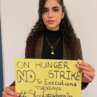 Solidaritätsaktion für die Kampagne „Dienstage gegen Hinrichtungen“: Person mit gelbem Schild gegen Hinrichtungen im Iran.