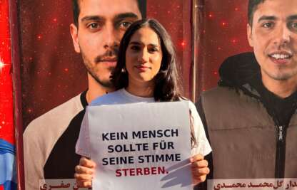 Teilnehmerin beim Solidaritätslauf in Köln mit dem Schild „Kein Mensch sollte für seine Stimme sterben“.