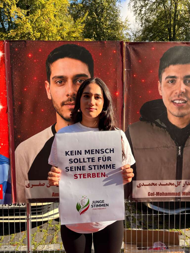 Teilnehmerin beim Solidaritätslauf in Köln mit dem Schild „Kein Mensch sollte für seine Stimme sterben“.